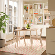 Modern dining room with a table, chairs, and a bookshelf.