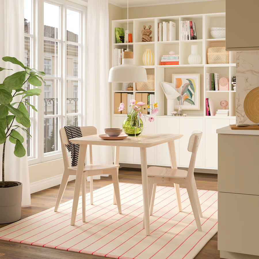 Modern dining room with a table, chairs, and a bookshelf.